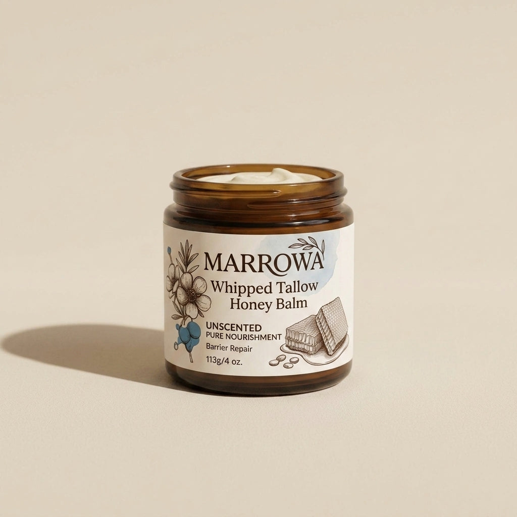 Marrowa whipped tallow and raw honey balm, unscented, in an open glass jar on an oatmeal panel